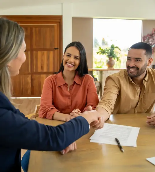 a woman shaking hands with a man at a table