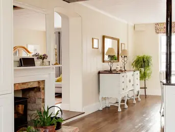 a room with a fireplace and a white dresser