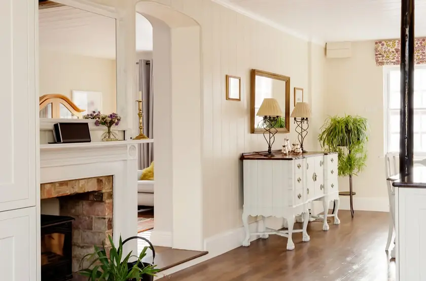 a room with a fireplace and a white dresser