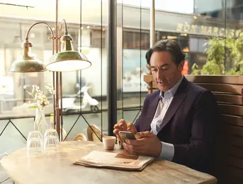 a man sitting at a table looking at his phone