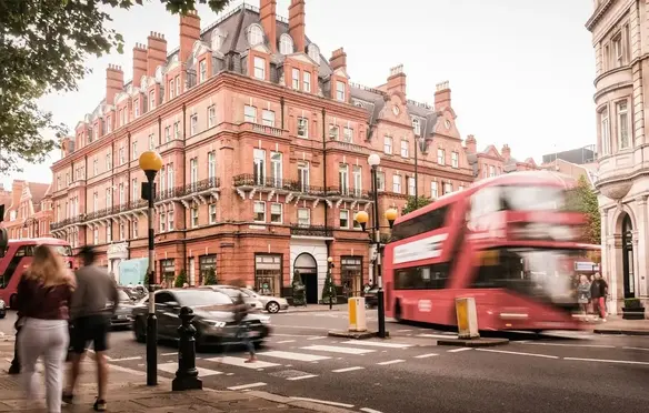 a double decker bus on a street in front of a brick building