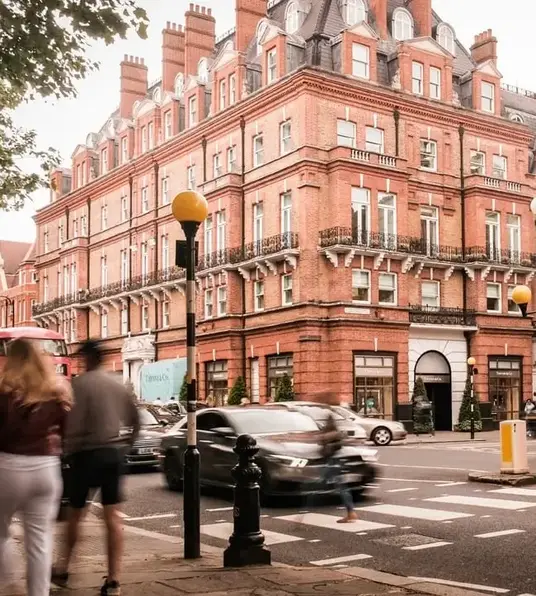 a double decker bus on a street in front of a brick building