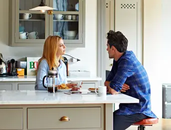a man and woman sitting at a table with food