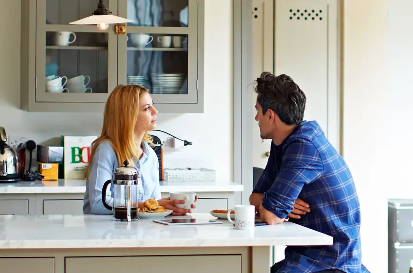 a man and woman sitting at a table with food