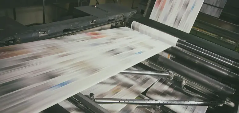a printing press with a few papers