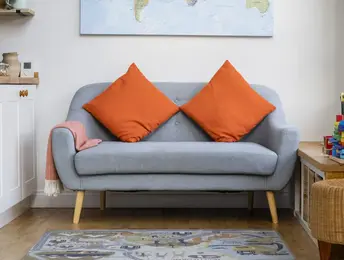 a couch with orange pillows on it