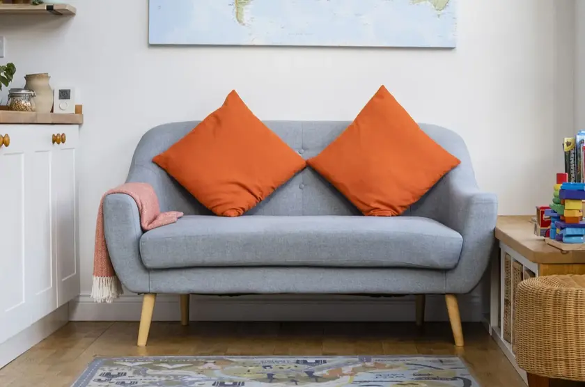 a couch with orange pillows on it