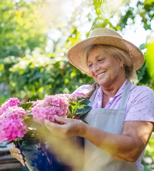 a woman holding a bucket of flowers