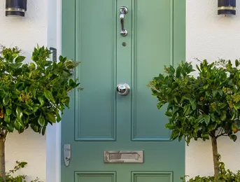 a green door with a handle and a doorknob