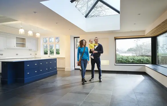 a man and woman walking in a kitchen