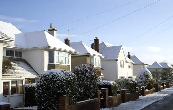 a row of houses with snow on the roof