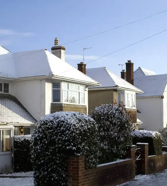a row of houses with snow on the roof