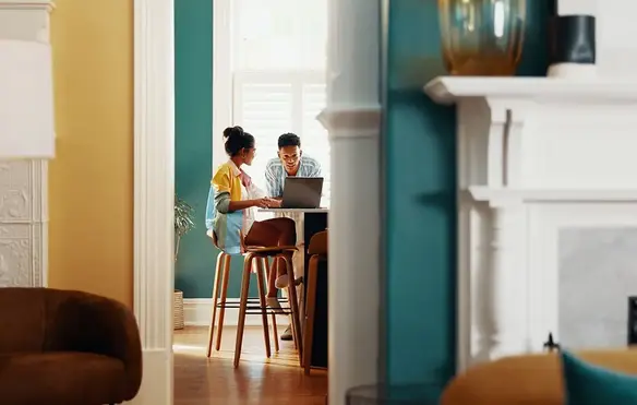 a man and woman looking at a laptop