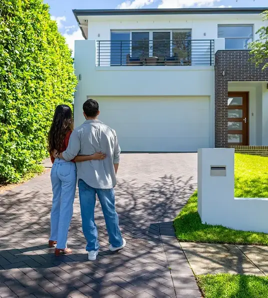 a man and woman standing in front of a house