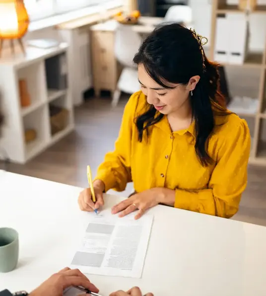 a woman signing a document